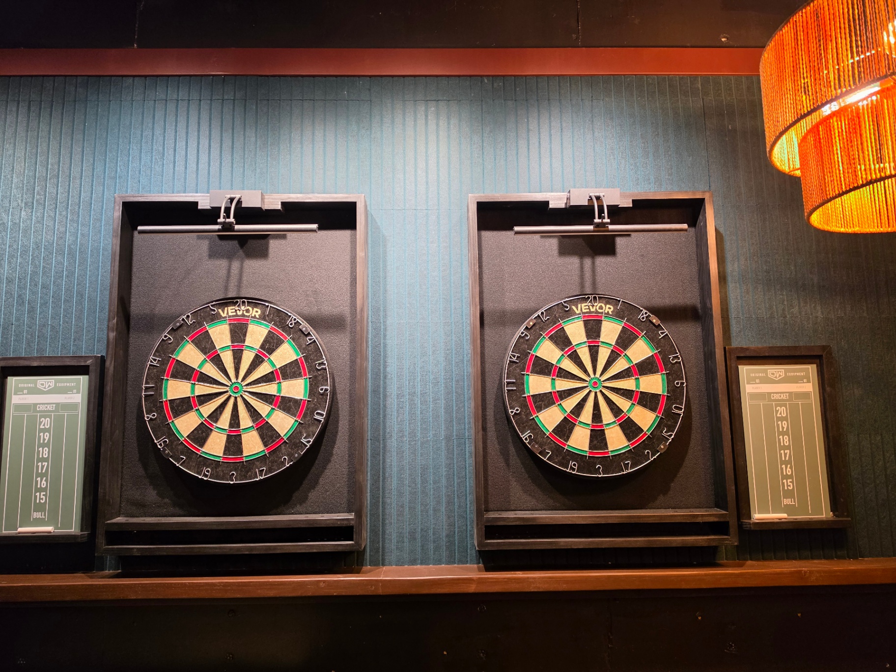 Twin dart boards with cricket scoreboards in the upstairs game area